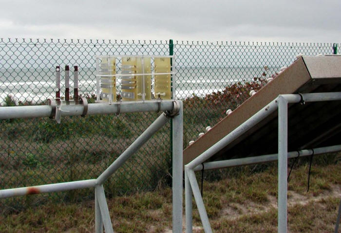 Metal coupons in a plastic test rack exposed at the Kennedy Space Center beach corrosion test site besides a CLIMAT coupon. (Courtesy of Battelle Institute)